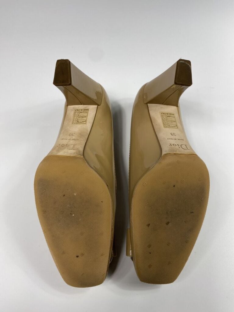 CHRISTIAN DIOR - Escarpins en cuir verni beige, orné d'une plaque en métal doré…