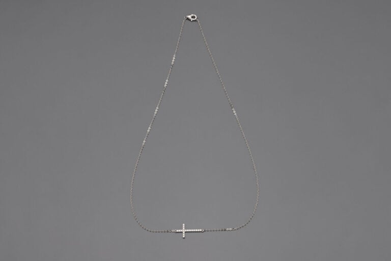 COLLIER chaînette en or gris (750‰) retenant une croix horizontale sertie de di…