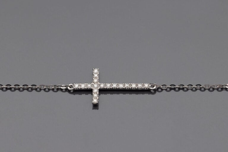 COLLIER chaînette en or gris (750‰) retenant une croix horizontale sertie de di…
