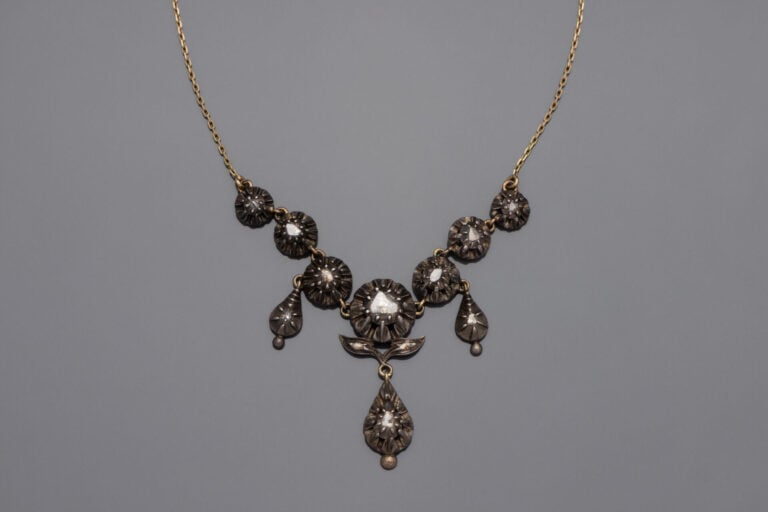 COLLIER composé d'une chaînette en or jaune (750‰) retenant un motif en argent…