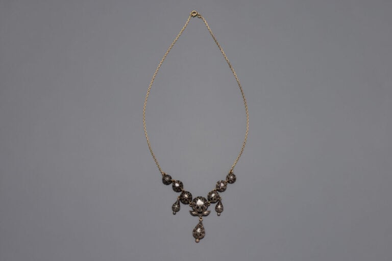 COLLIER composé d'une chaînette en or jaune (750‰) retenant un motif en argent…
