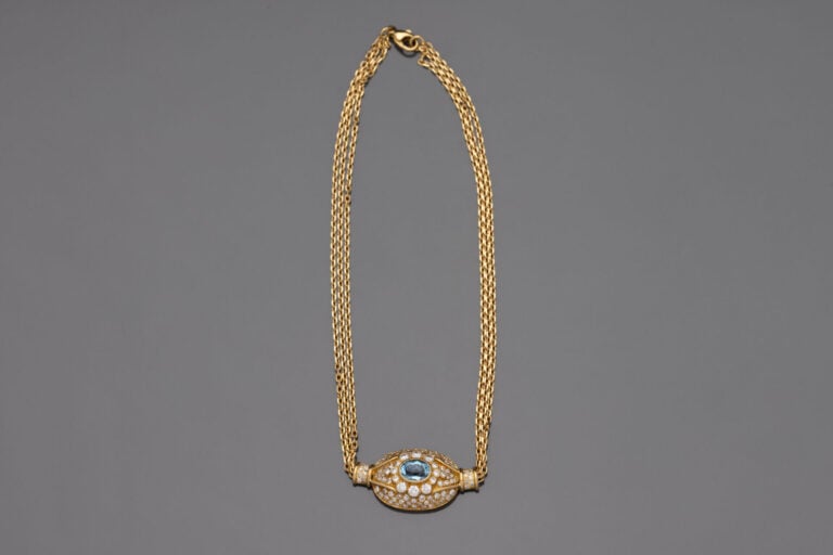 COLLIER composé de trois chaînettes en or jaune (750) retenant un motif central…