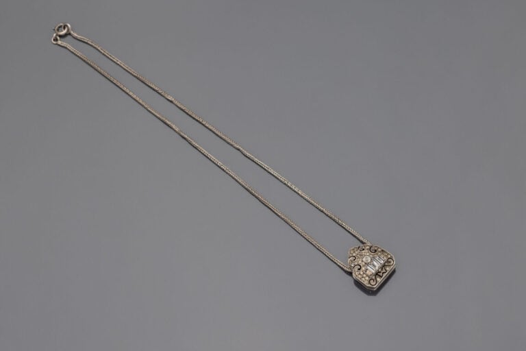 Collier en argent (800) à maille serpentine retenant un pendentif agrafe à déco…