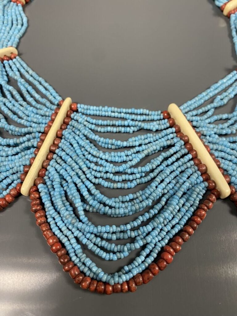 Collier plastron orné de multiples rangs de billes turquoises souligés de bille…