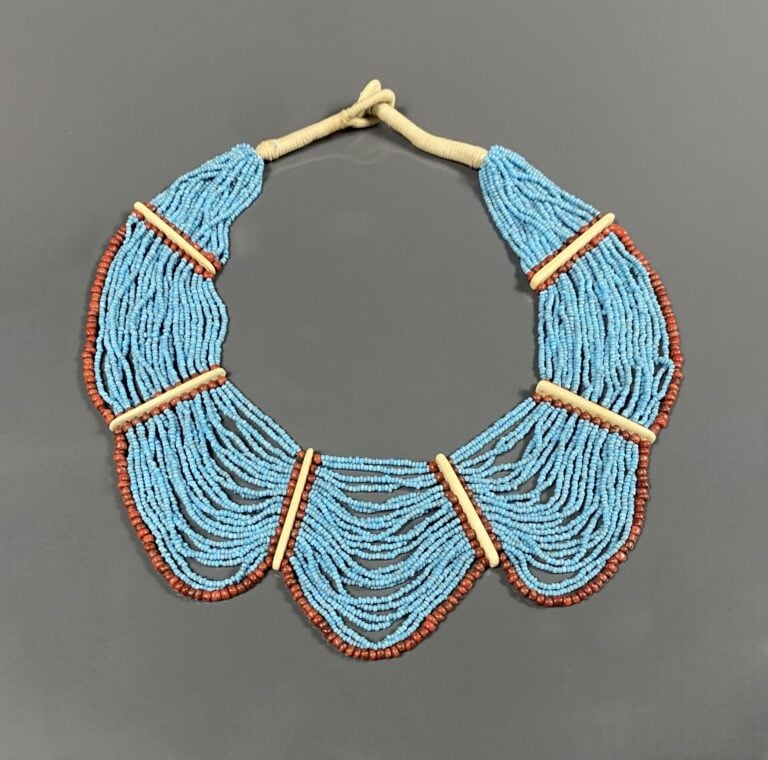 Collier plastron orné de multiples rangs de billes turquoises souligés de bille…