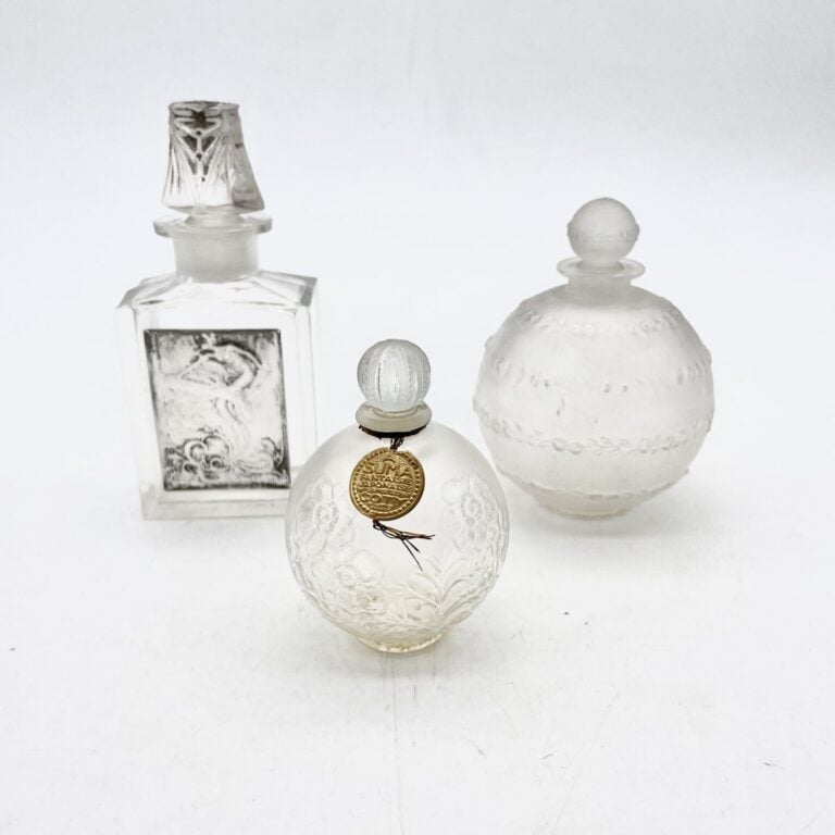 COTY, 3 flacons en verre Lalique dont : - - "Asuma", flacon boule fleurie avec…