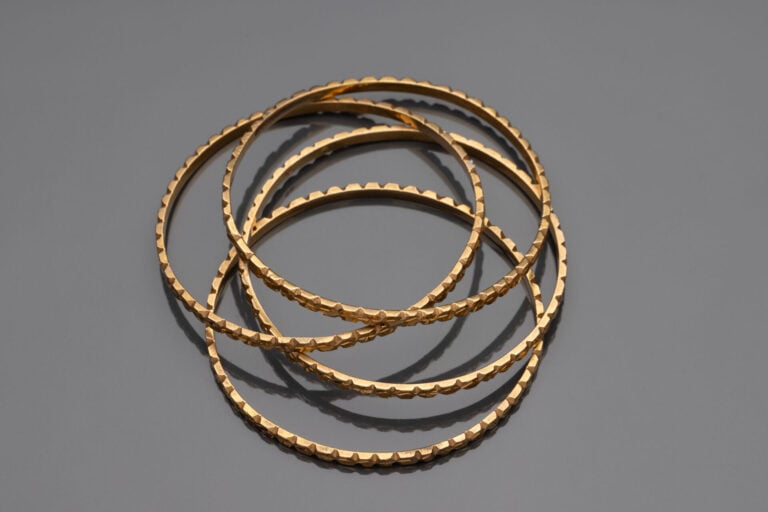 Ensemble de quatre bracelets joncs en or jaune (750) à décor ciselé - Travail m…