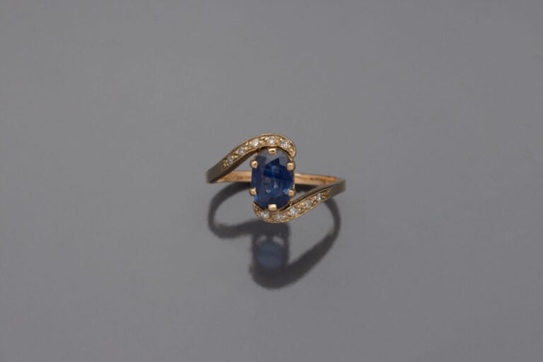 Fine BAGUE en or jaune (750) de forme sinueuse ornée d'un saphir ovale souligné…
