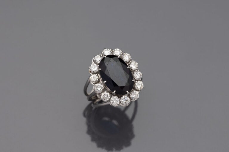 Importante BAGUE " marguerite " en fil d'or gris (750) ornée d'un saphir foncé…