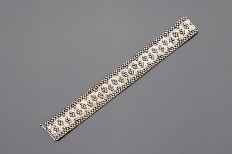 Large BRACELET ruban en or gris (750) partiellement amati. - Vers 1970. Dans so…
