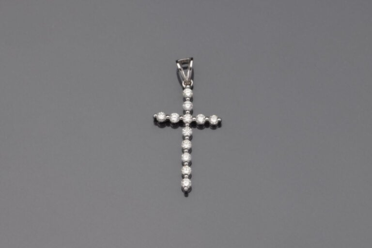 PENDENTIF "fine croix" en or gris (750‰) serti de douze diamants taille brillan…