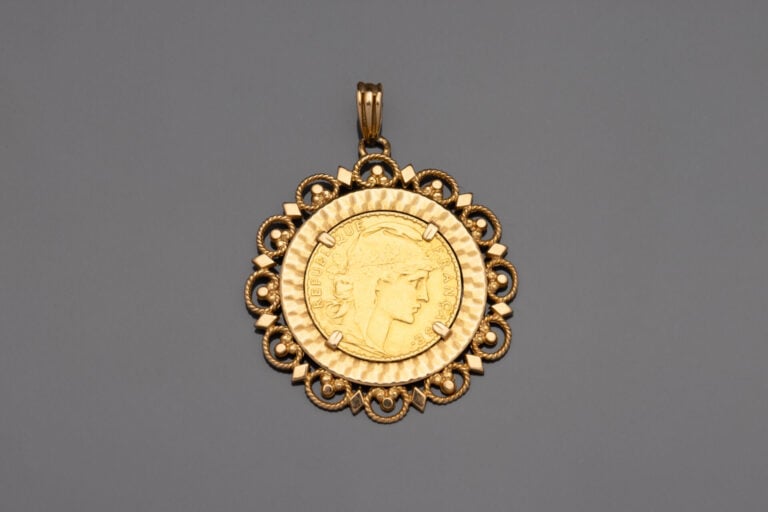 Pendentif médaillon retenant une pièce de 20 francs or 1912, dans un entourage…
