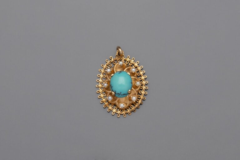 PENDENTIF ovale en or jaune (750) ajouré et repoussé serti d'un cabochon de tur…