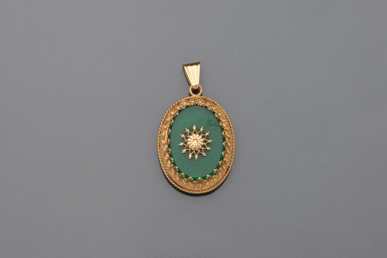 PENDENTIF porte-souvenir de forme ovale en or jaune (750), ouvrant à charnières…