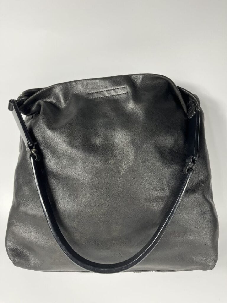 PRADA - Sac seau en agneau noir souple, porté épaule, anse en résine noire arti…