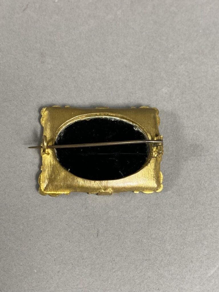 Broche de forme rectangulaire en pomponne ornée d'une entaille sur onyx représe…