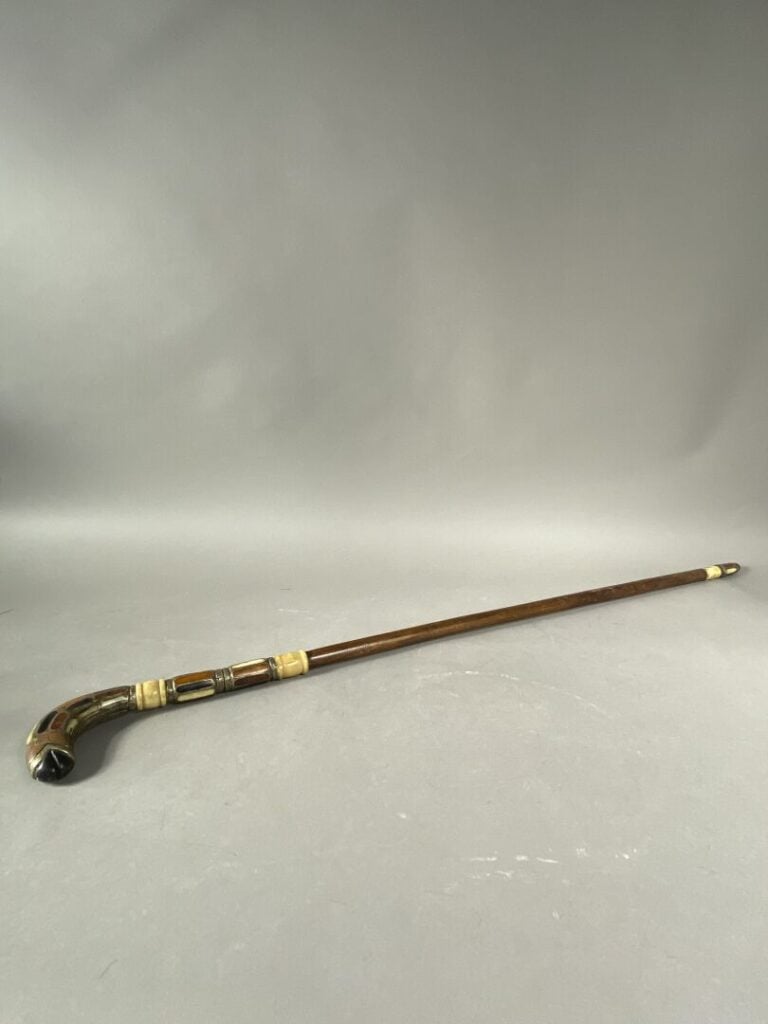 Canne à système en bois et incrustations de pierres dures, le pommeau formant u…