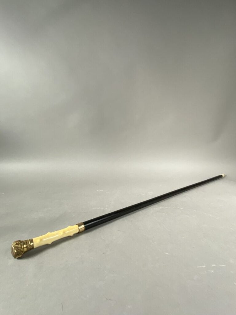 Canne de douairière en bois noirci à pommeau en bronze doré de rinceaux. - L: 9…