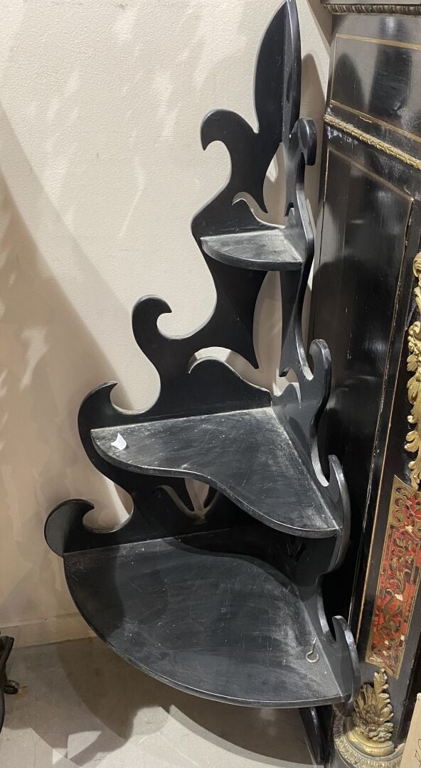 Etagère en bois noirci mouluré et sculpté d'enroulements, surmontée d'un fronto…