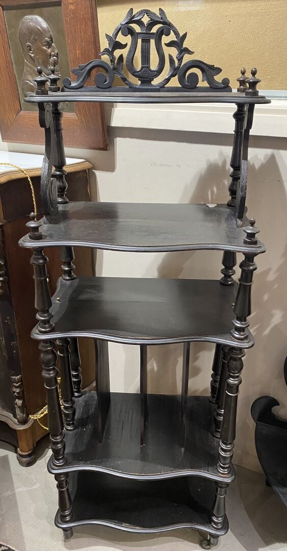 Etagère en bois noirci mouluré et sculpté d'enroulements, surmontée d'un fronto…
