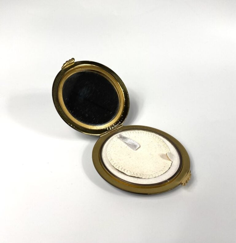 GUCCI - Poudrier siglé en métal doré émaillé noir, miroir (signé) - Diam. 8 cm…
