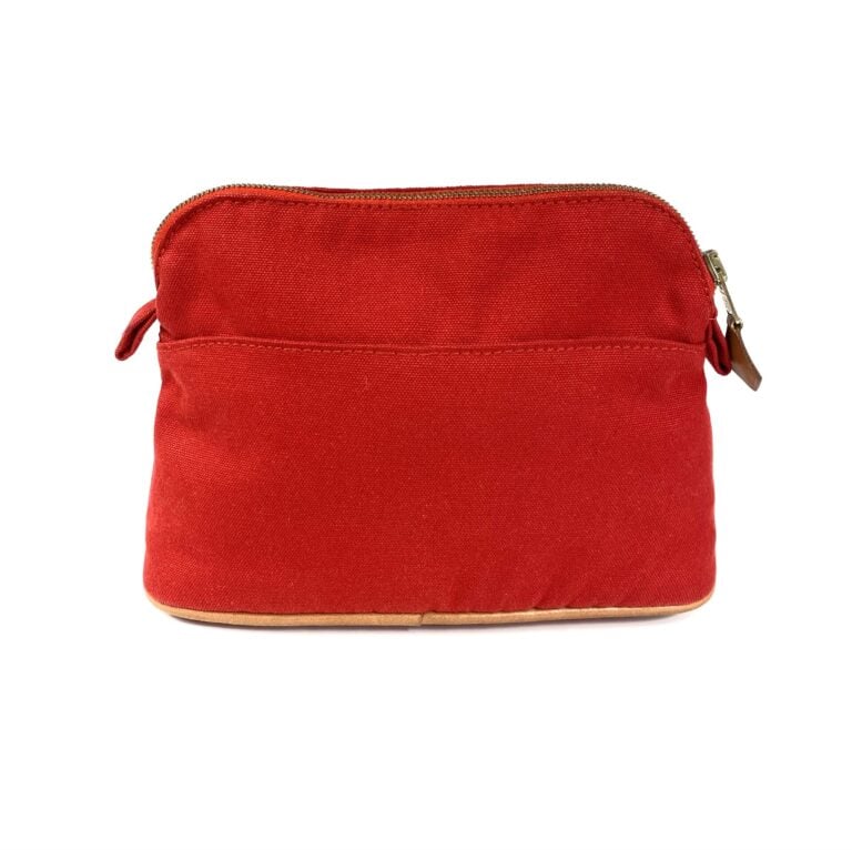 HERMÈS - Trousse de voyage "Bolide" en toile de coton rouge et cuir gold, modèl…