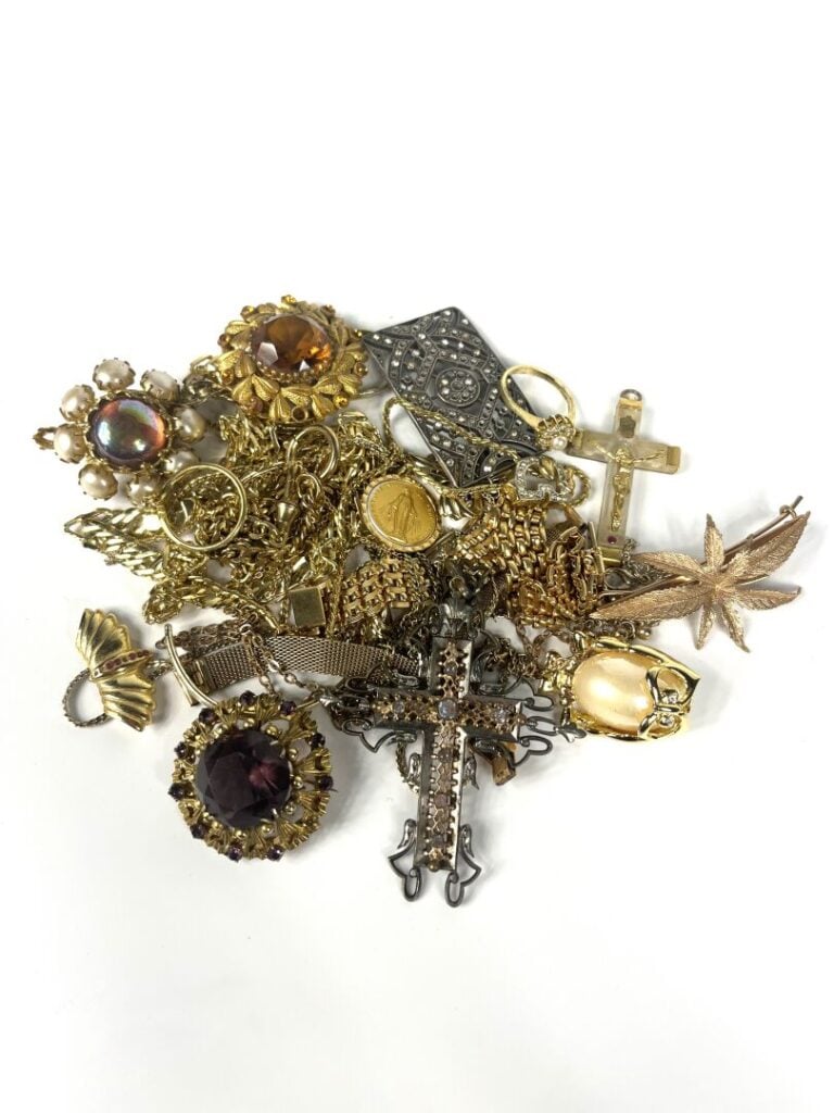 Lot de bijoux fantaisie comprenant notamment des colliers et broches dorés, pie…