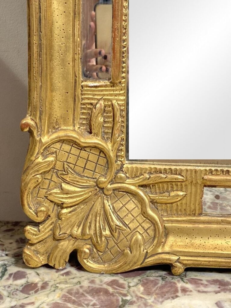 Miroir à parecloses en bois et stuc doré à fronton ajouré orné d'un bouquet fle…