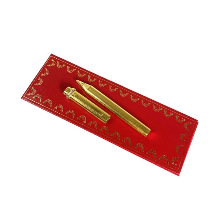 MUST DE CARTIER - Stylo bille "Trinity" en métal plaqué or strié, numéroté. - L…