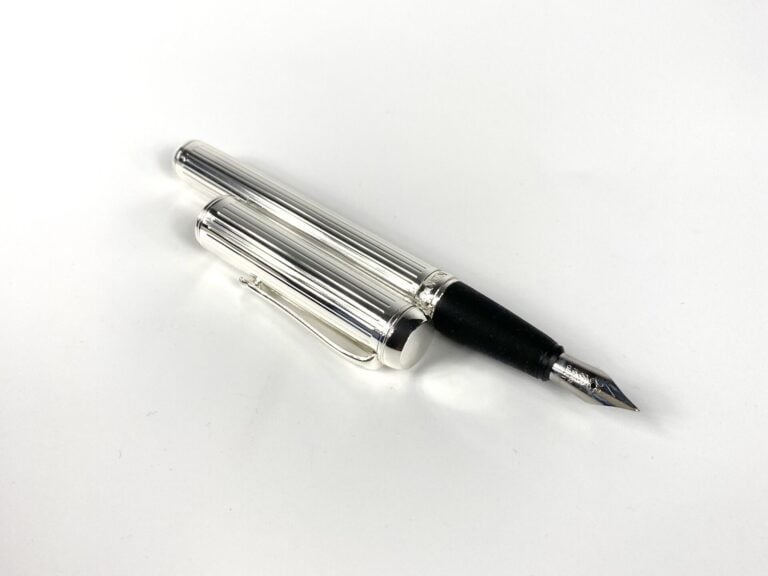 NINO CERRUTI - Stylo-plume en métal argenté strié, dans son étui. - 14 cm - Bon…