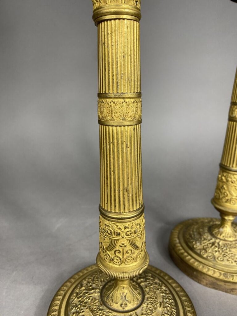 Paire de bougeoirs en bronze doré ciselé, le fût en forme de colonne cannelée o…