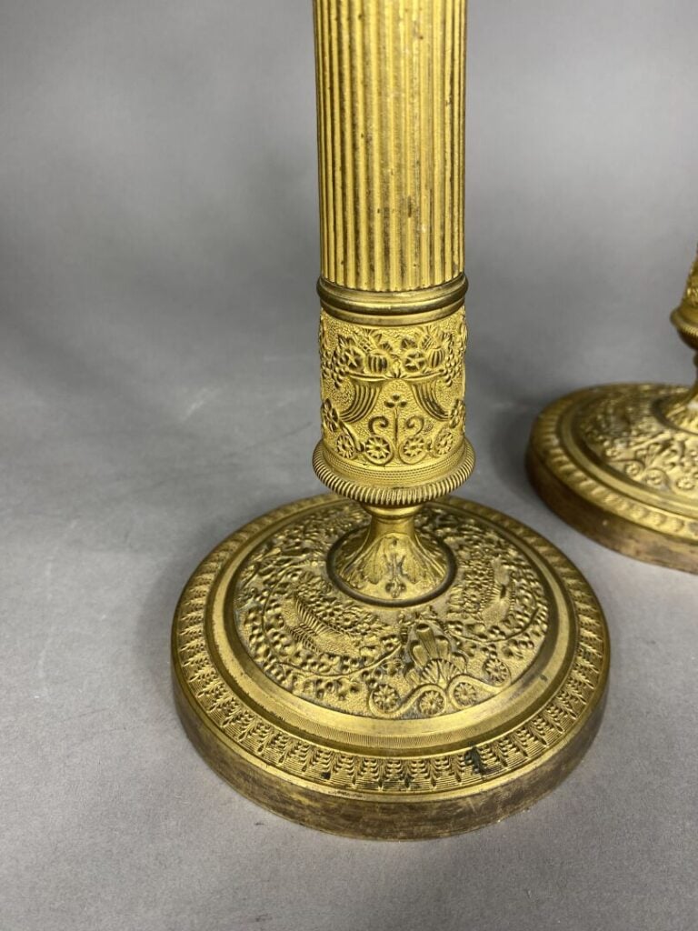 Paire de bougeoirs en bronze doré ciselé, le fût en forme de colonne cannelée o…