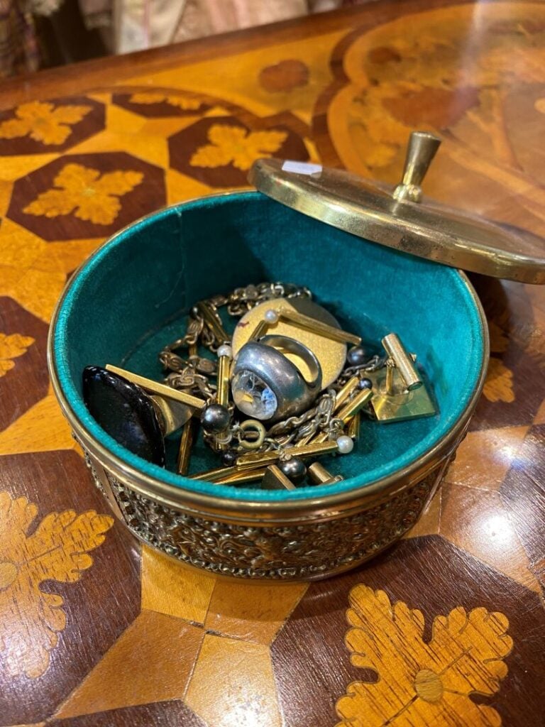 Petit lot de bijoux fantaisie divers présenté dans une boite en métal doré à dé…