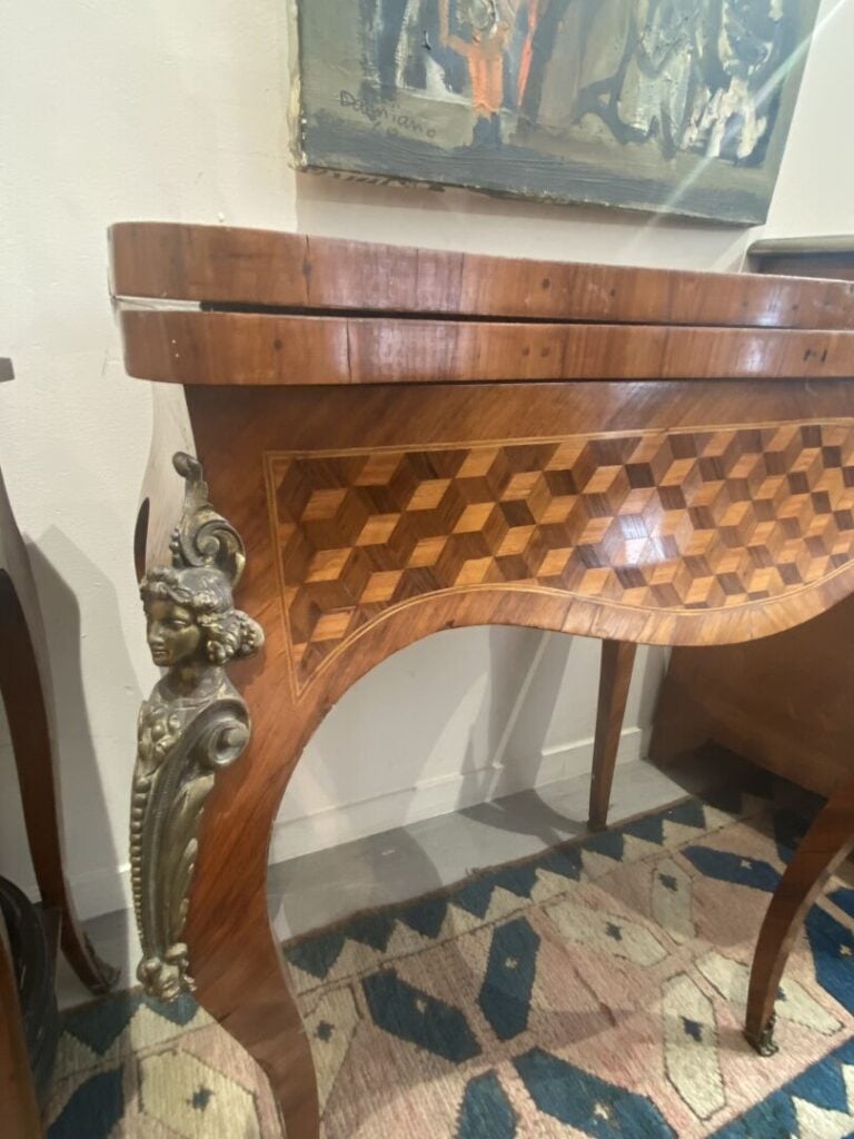 Table à jeux de forme mouvementée en bois de placage à décor marqueté de cubes…