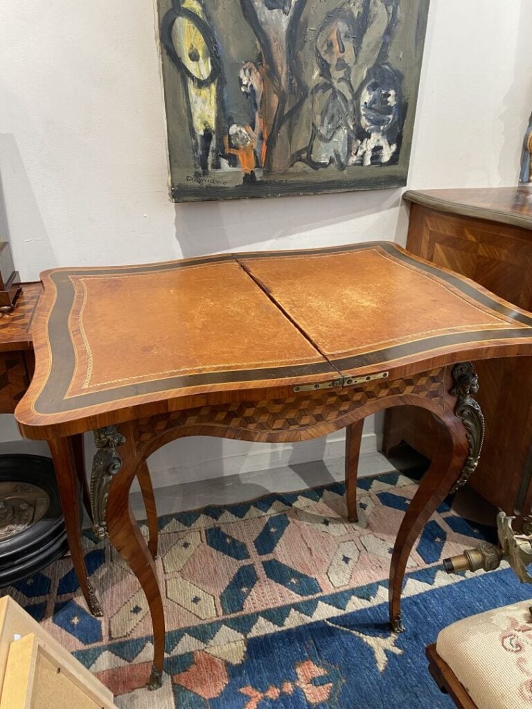 Table à jeux de forme mouvementée en bois de placage à décor marqueté de cubes…