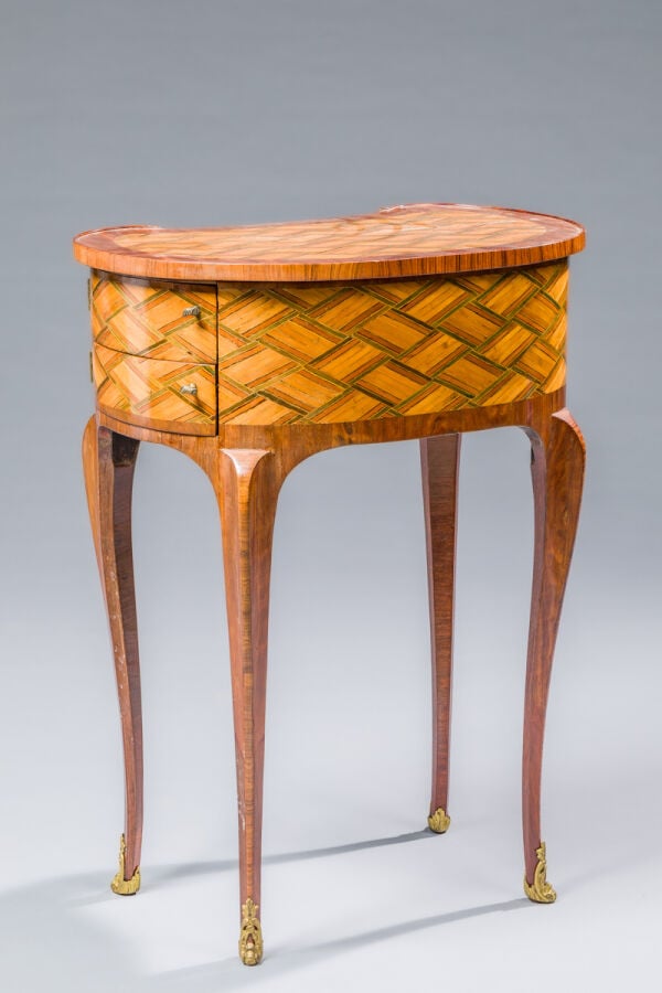 Table de salon de forme haricot marquetée à décor géométrique de jeux de filets…