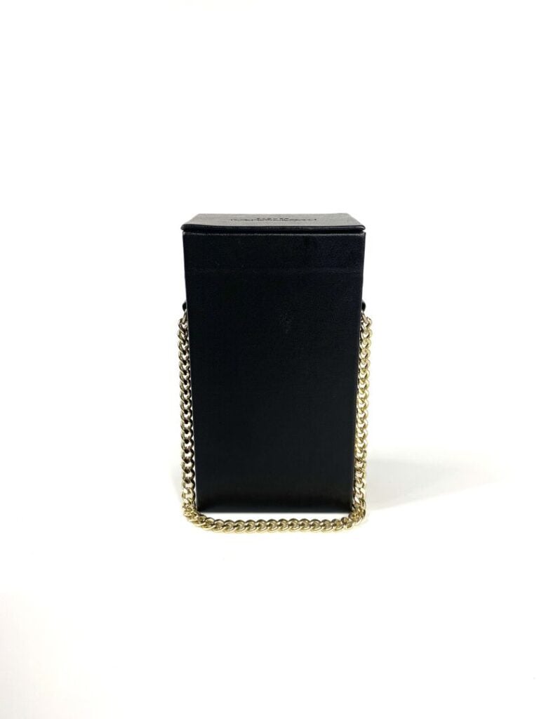 YVES SAINT LAURENT Beauté - Minaudière noire et dorée, chaînette dorée. - 7 x 1…