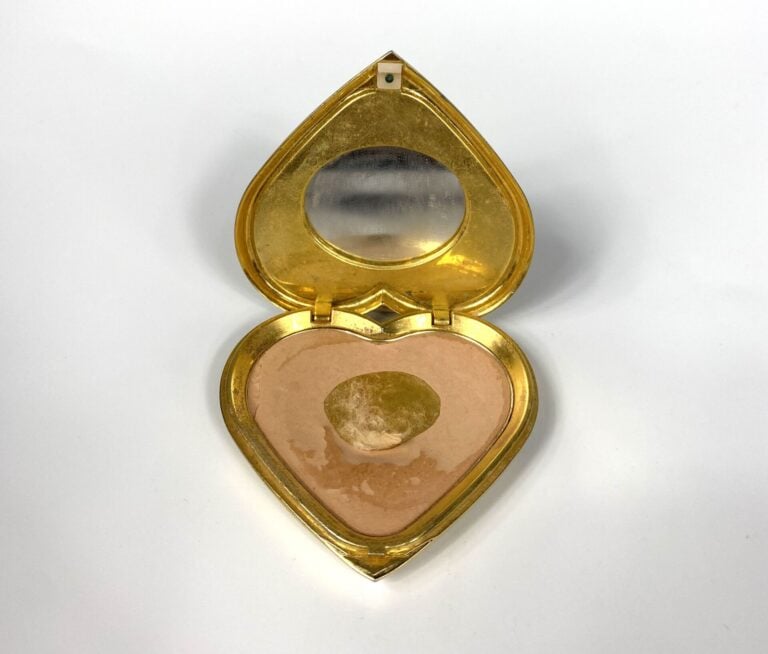 YVES SAINT LAURENT - Poudrier coeur en métal doré rehaussé de strass bleus, mir…