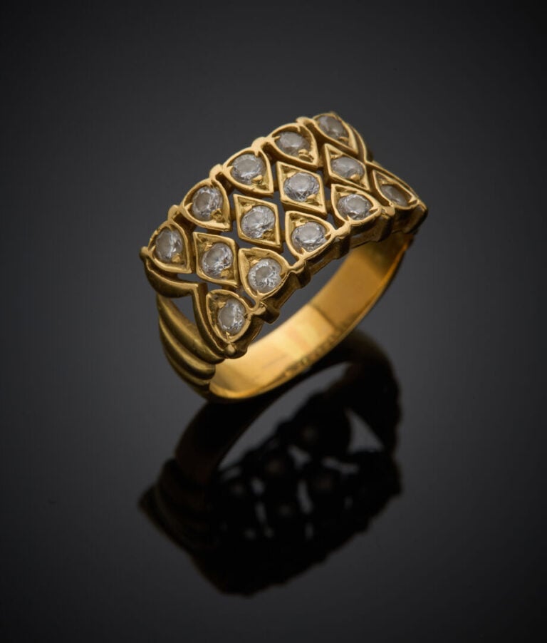 BAGUE bandeau en or jaune (750‰) godronné et ajouré, serti de diamants taille b…