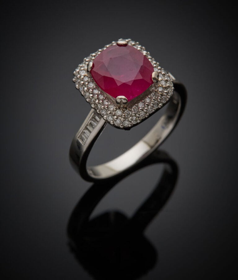 BAGUE en or gris (750‰) serti d'un rubis de forme coussin, entouré et épaulé de…