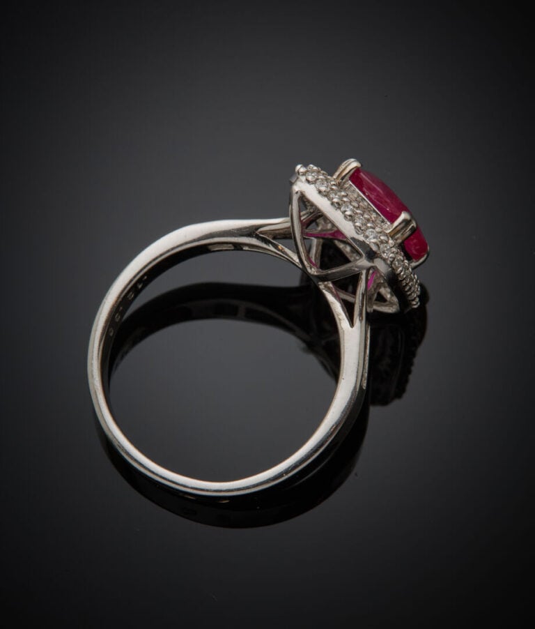 BAGUE en or gris (750‰) serti d'un rubis de forme coussin, entouré et épaulé de…