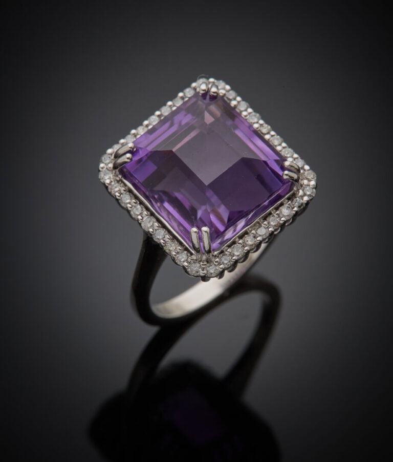 BAGUE en or gris (750‰) serti d'une améthyste carrée taillée à degrés, dans un…