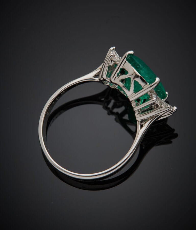 BAGUE en or gris (750‰) serti d'une émeraude de forme ovale, épaulé de diamants…