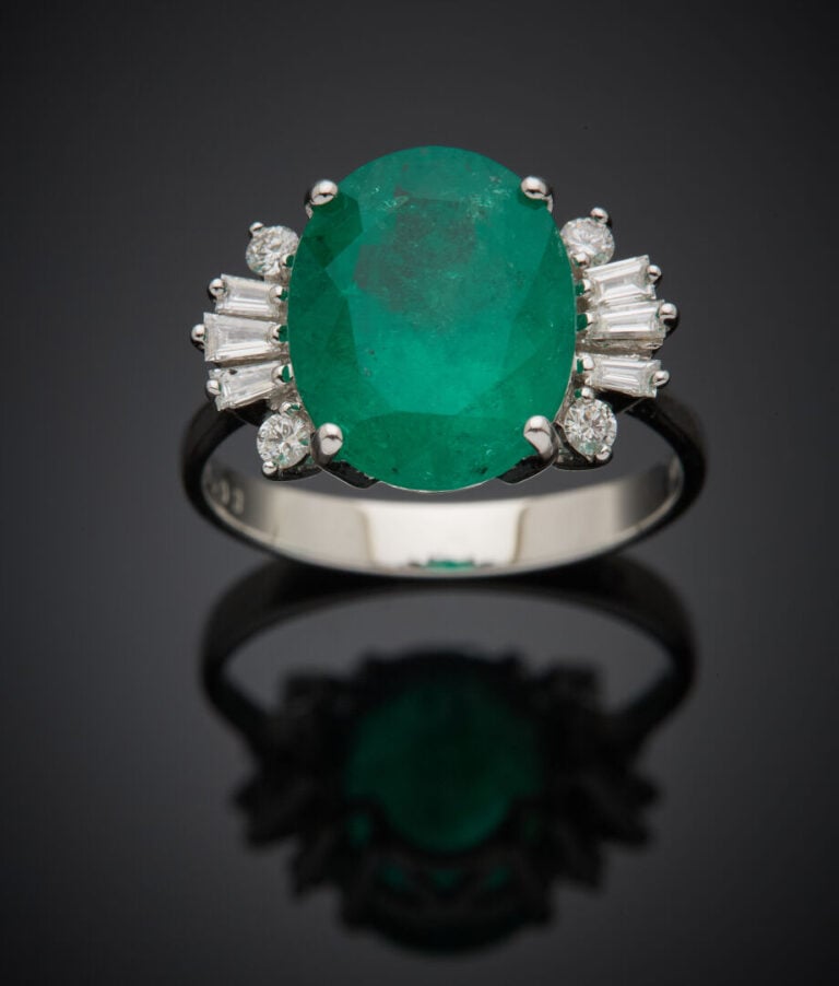 BAGUE en or gris (750‰) serti d'une émeraude de forme ovale, épaulé de diamants…