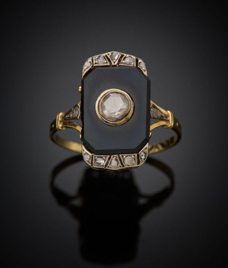 BAGUE en or jaune (750‰) ajouré surmontée d'une plaque en onyx flanquée de diam…