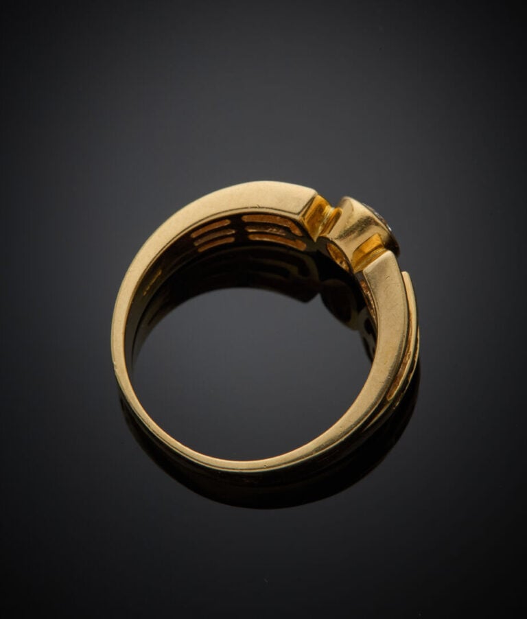 BAGUE en or jaune (750‰) centrée d'un diamant ovale en serti clos, épaulé d'ali…