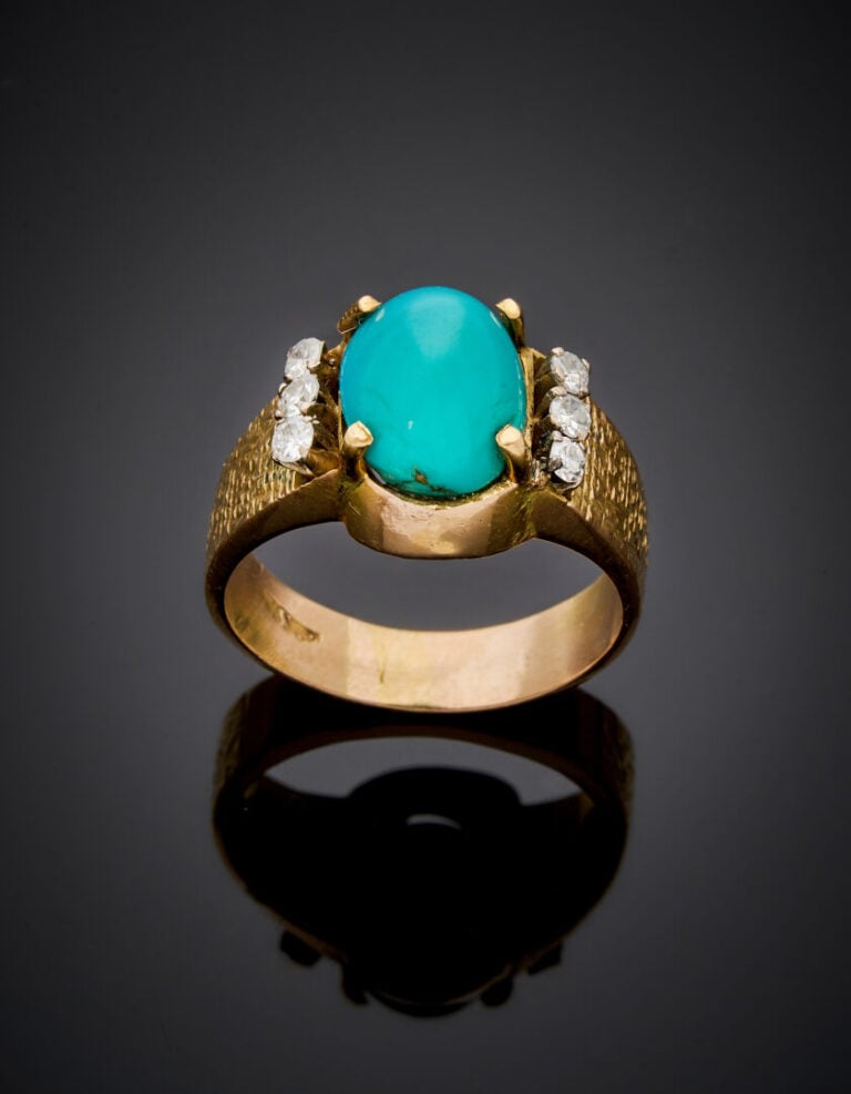 BAGUE en or jaune (750‰) finement ciselé, orné d'une turquoise cabochon, épaulé…