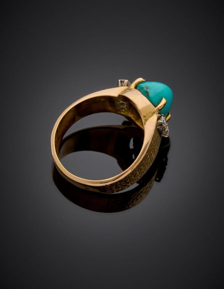BAGUE en or jaune (750‰) finement ciselé, orné d'une turquoise cabochon, épaulé…