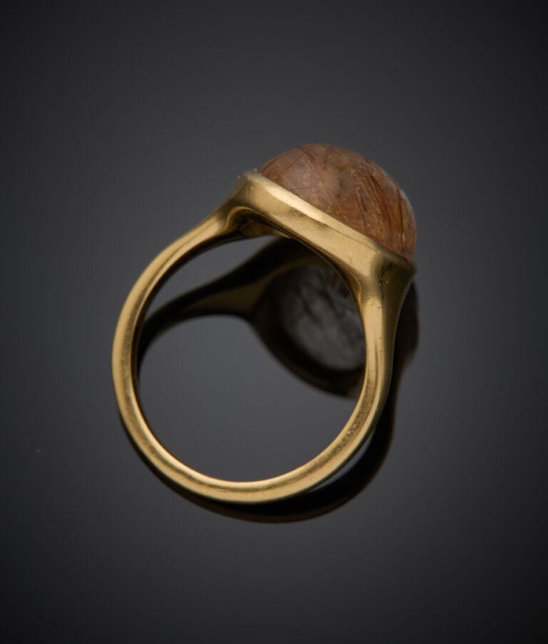 BAGUE en or jaune (750‰) ornée d'un cabochon de quartz rutile en serti clos. -…