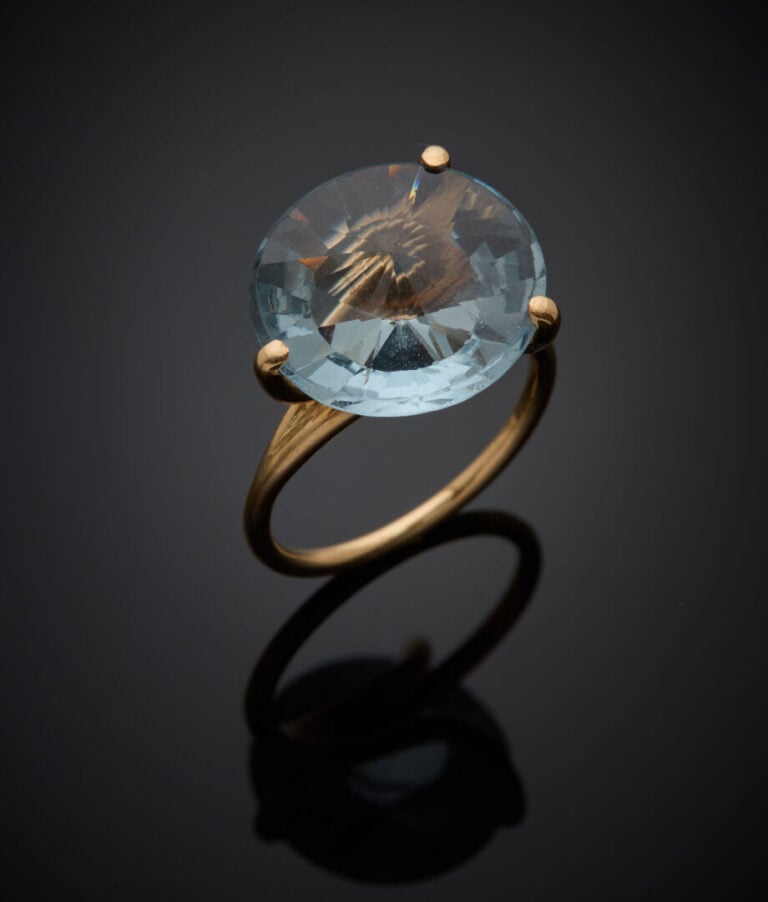 BAGUE en or jaune (750‰) serti d'une topaze bleue ronde de taille fantaisie. -…
